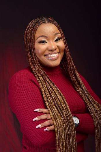 Lady with red shirt and long braids smiling